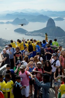 People cheering in the direction of a drone with cameras
