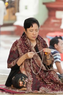 Buddhist woman in morning prayer at the Shwedagon Pagoda