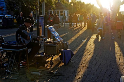 Street musician playing at the Fisherman Wharf in the evening light