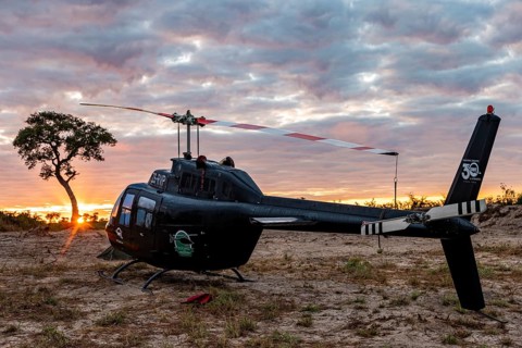 Helicopter in the African savannah at sunset