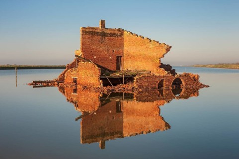 Ruins off a red brick building in a lagoon