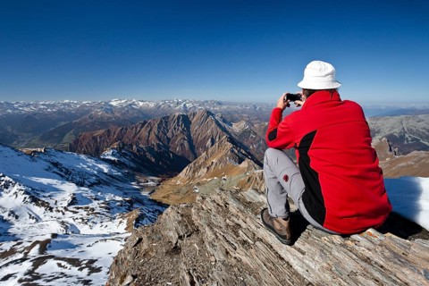 Mountain climber on the summit of Wilde Kreuzspitze Mountain with views over the Pfunderer Mountains towards the Wipptal valley
