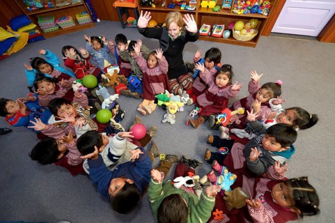 Children sitting on the floor in a circle in a kindergarten