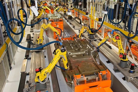 Robots at work in the underbody sealing and underbody coating station of the paint shop at Chrysler's Sterling Heights Assembly Plant
