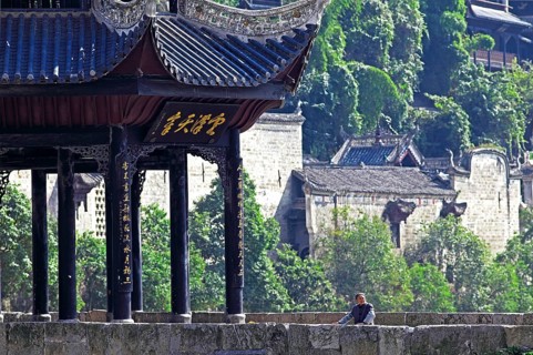 Old woman standing next to the Kuixingge Pagoda