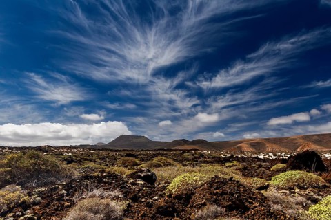 Cirrus clouds over volcanic landscape