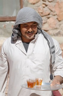 Modern Bedouin man carrying a tray with tea