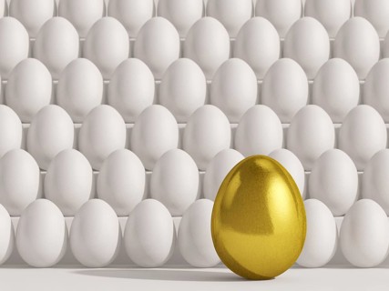 Large golden egg in front of white eggs