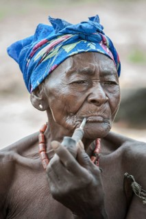 An elderly woman from the Koma people smoking a pipe