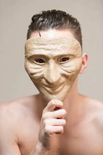 Man hiding behind a happy mask
