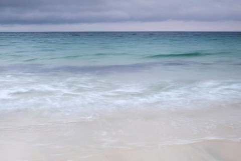 Spray and waves running on a sandy beach