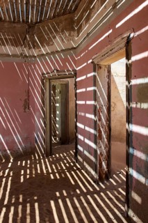 Light passing through the laths of a decaying house in the former diamond miners settlement that is slowly covered by the sand of the Namib Desert