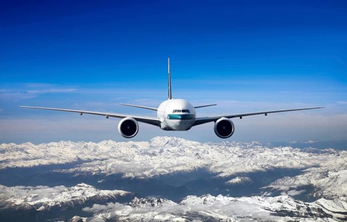 Cathay Pacific Boeing 777-367 ER in flight over mountains