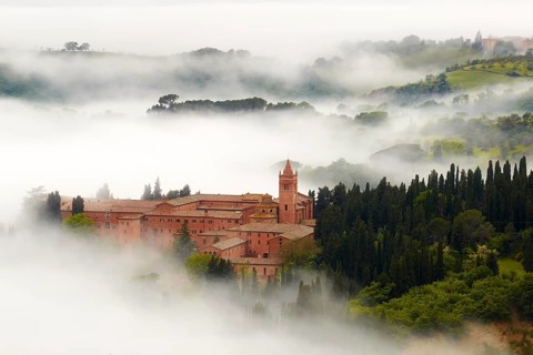 Monte Oliveto Maggiore abbey with mist-shrouded valleys