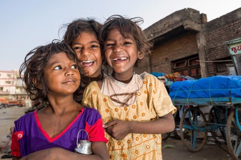Three smiling street kids