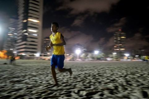 Brazilian teenager training at night on the beach for the Street Children World Cup 2014