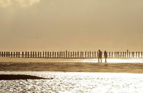Couple walking in front of groynes