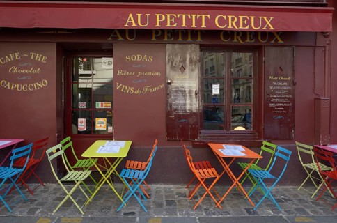 Colourful tables and chairs outside the street cafe 'Au Petit Creux'