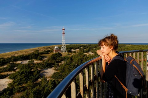 Young woman looking out from the Leuchtturm Darsser Ort lighthouse
