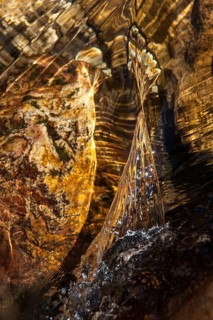 Closeup of a water stream flowing over a rock