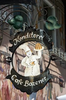 Wrought iron hanging shop sign of the Konditorei Cafe Bozener pastry cafe