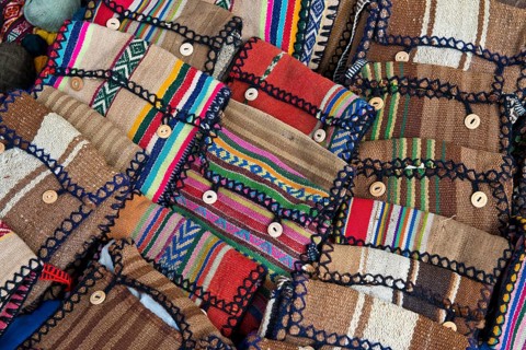 Handmade bags with the traditional patterns of the Quechua Indians are displayed for sale