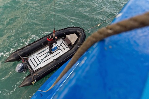 Inflatable boat being hoisted aboard an expedition ship following an excursion