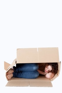 Young woman sleeping in a removal box