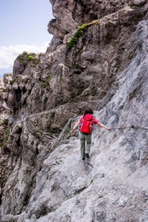 Female hiker walking along the fixed cable route of Jubilaeumssteig