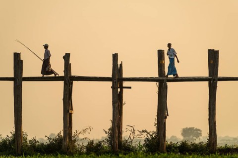 Locals walking on a teak bridge