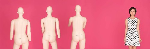 Woman standing next to a group of mannequins