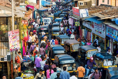 Many people and motor rikshaws causing a roadblock in a very busy market area