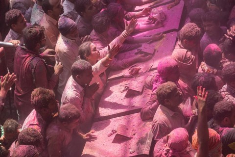 Devotees covered in coloured powder praying