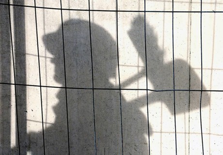 Shadow of a construction worker on a concrete wall