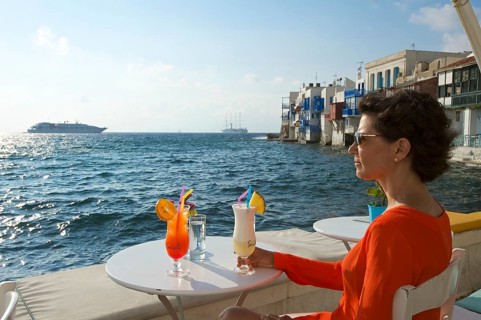 Woman enjoying a cocktail and a view over the sea
