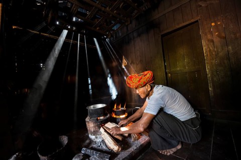 Elderly man at an open fire in the hut