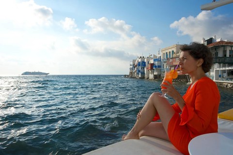 Woman enjoying a cocktail and a view over the sea