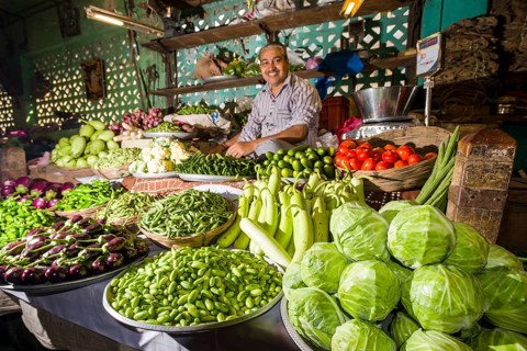 Man selling vegetables at a vegetable market