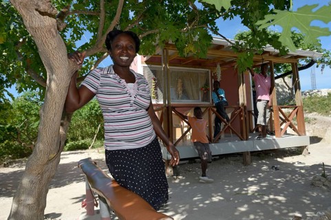 Woman standing in front of the house which she received from an aid organisation after the earthquake