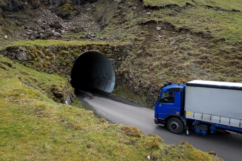 Truck driving into a single-track tunnel between Husar and Mikladalur
