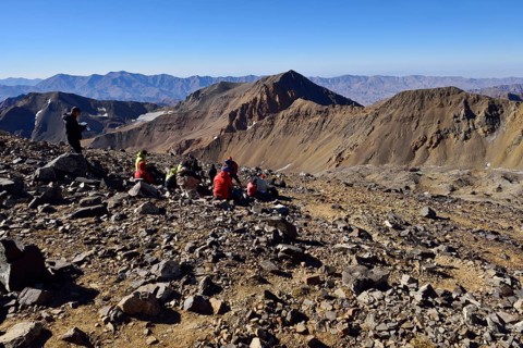 Group of hikers resting on the way to Alam Kuh