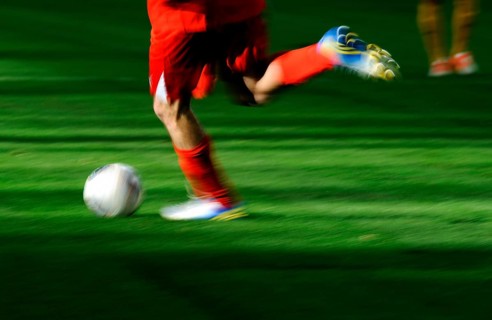 A football player's legs with a football