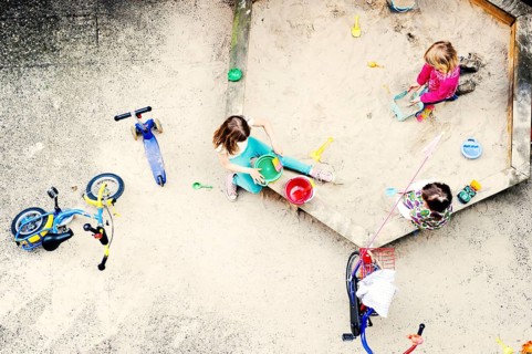 Children playing in the sandbox of a backyard