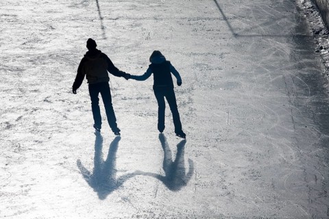 Man and woman holding hands ice skating