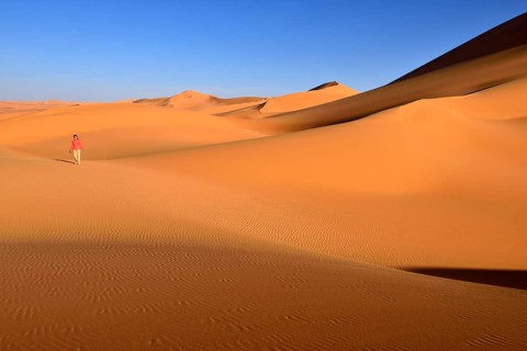 Woman walking in the dunes of In Tehak