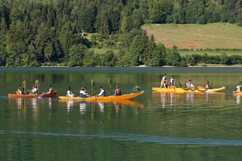 Locals wearing traditional costumes in decorated wooden Platte boats