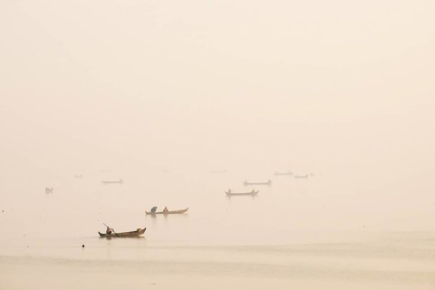 Fishermen in their boats in the morning light