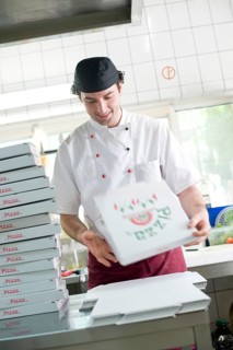 Pizza baker folding a pizza box