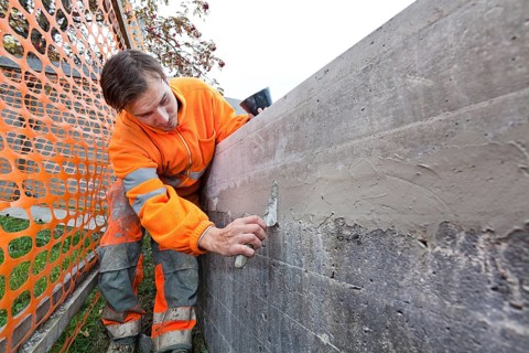Man doing concrete restoration and construction work on the main building of the HSG University of St. Gallen