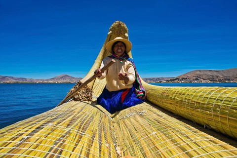 A local woman rowing a traditional boat made of totora reeds on Lake Titicaca